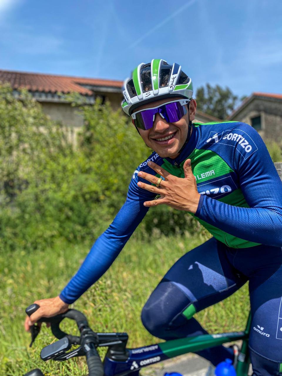 Cyclist in blue and green cycling gear, with 'Cortizo' logo and green ring
