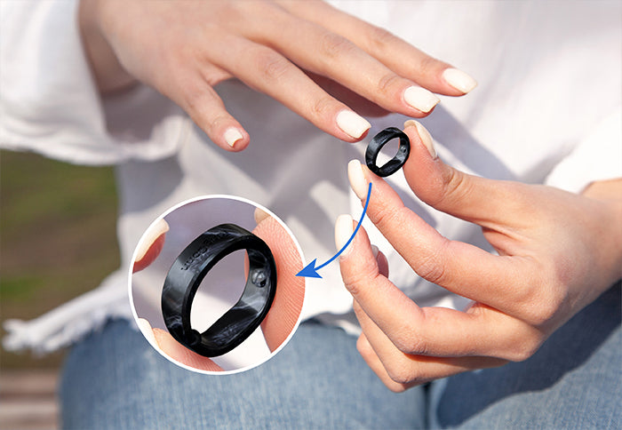 Black smart ring held by hands, showcasing design and details for health tracking