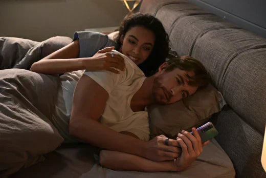 Couple checking sleep data of smart bracelet in bed