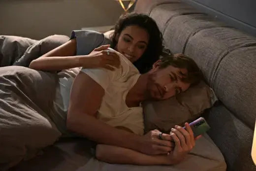 Couple checking sleep data of smart bracelet in bed